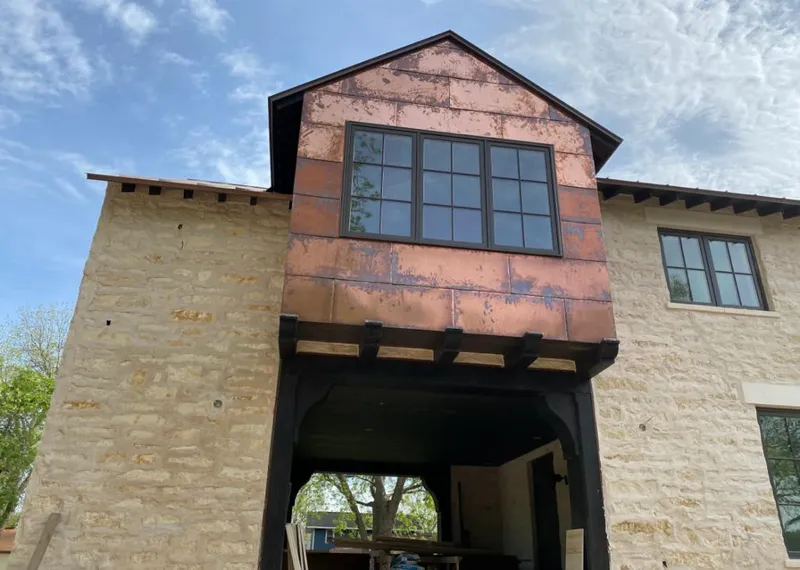 Copper metal panel facade on a stone building for Skylight Installation in Hutchins